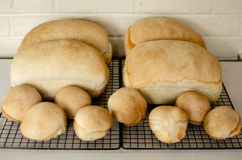 A rustic loaf of sourdough bread cooling on a wire rack